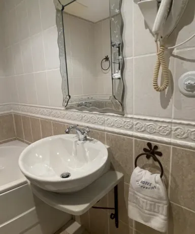 Baño con, espejo, secador de pelo, lavabo y bañera