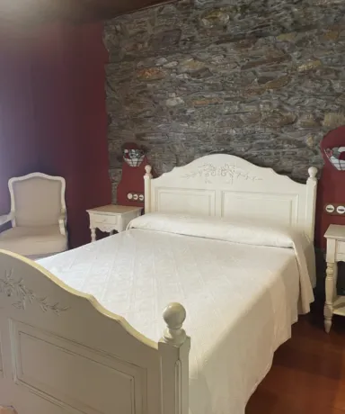 Habitación con cama, mesillas de noche y una silla