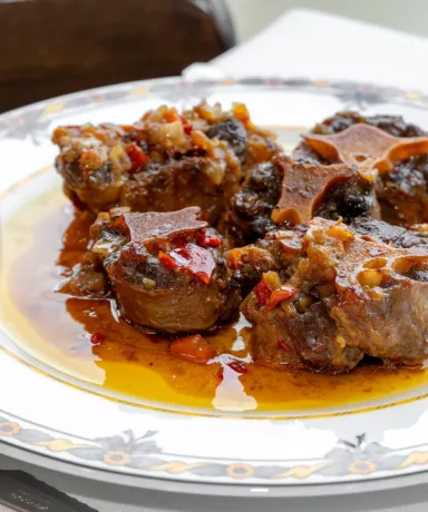 Rabo de toro emplatado junto a una copa de vino tinto