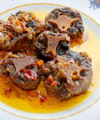 Rabo de toro emplatado junto a una copa de vino tinto